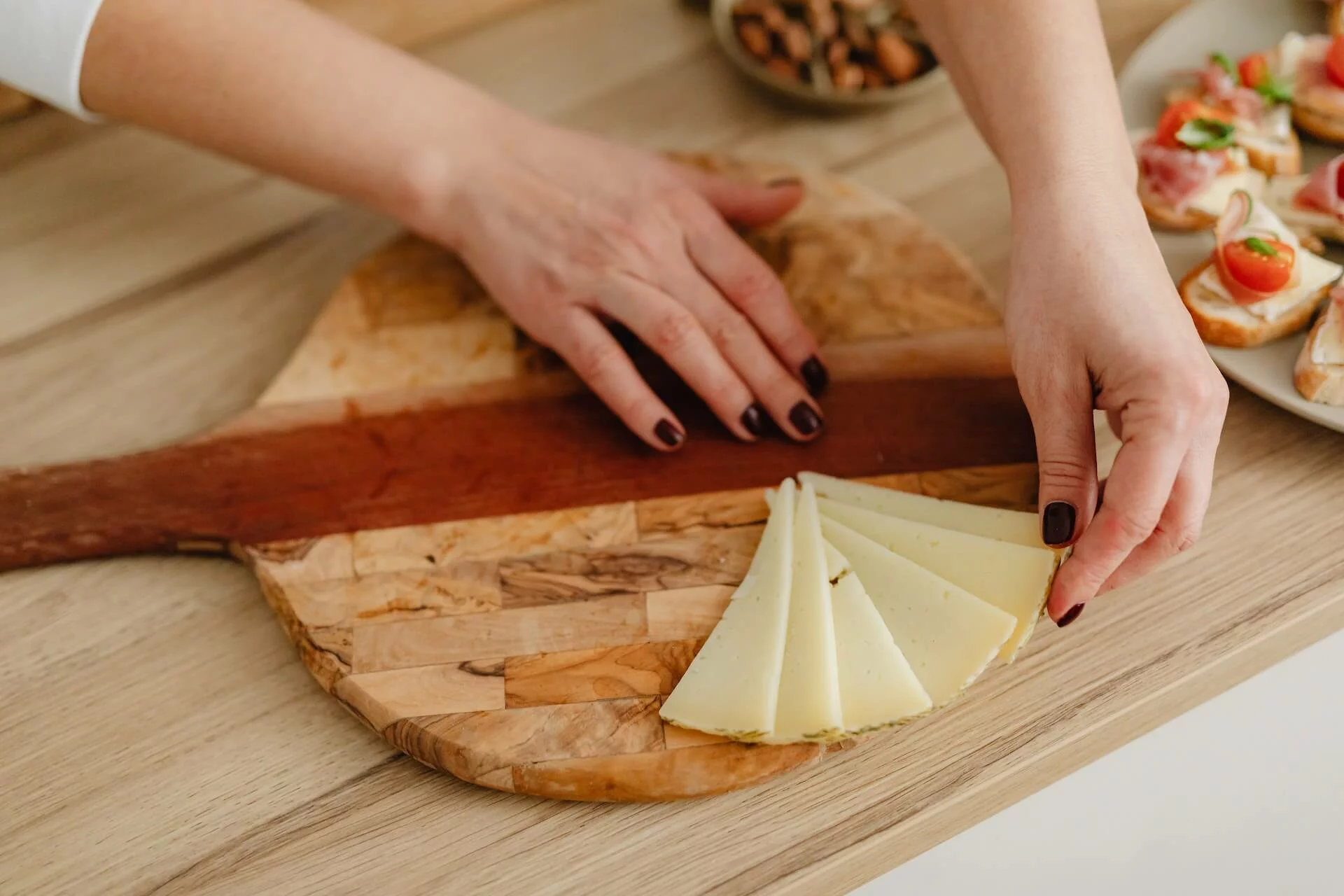 a person arranging the best cheese for snacking